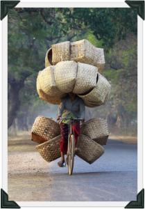 heres-a-woman-biking-with-baskets-to-sell-in-a-market-in-myanmar
